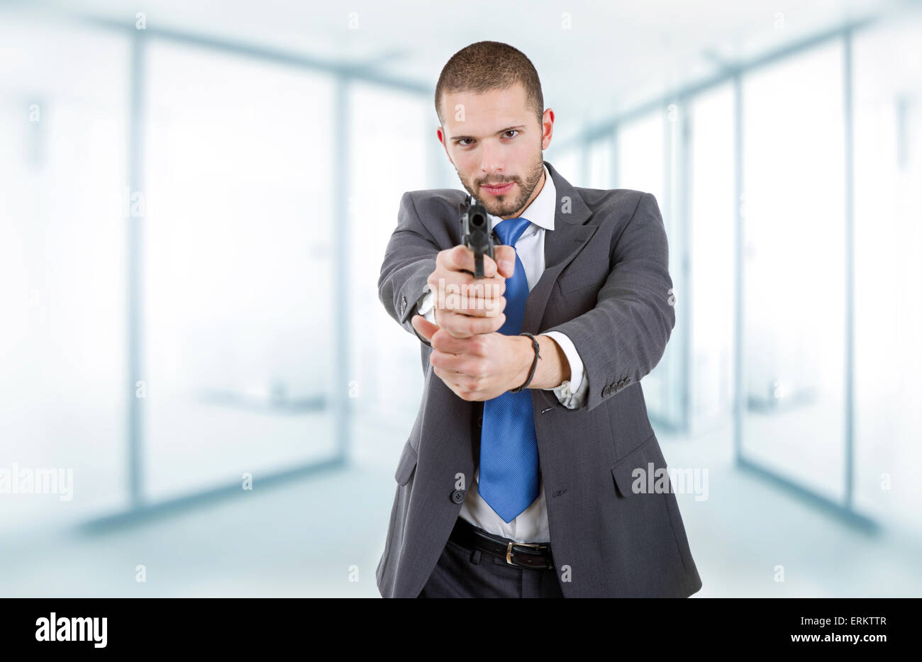 Giovane imprenditore con una pistola, presso l'ufficio Foto Stock