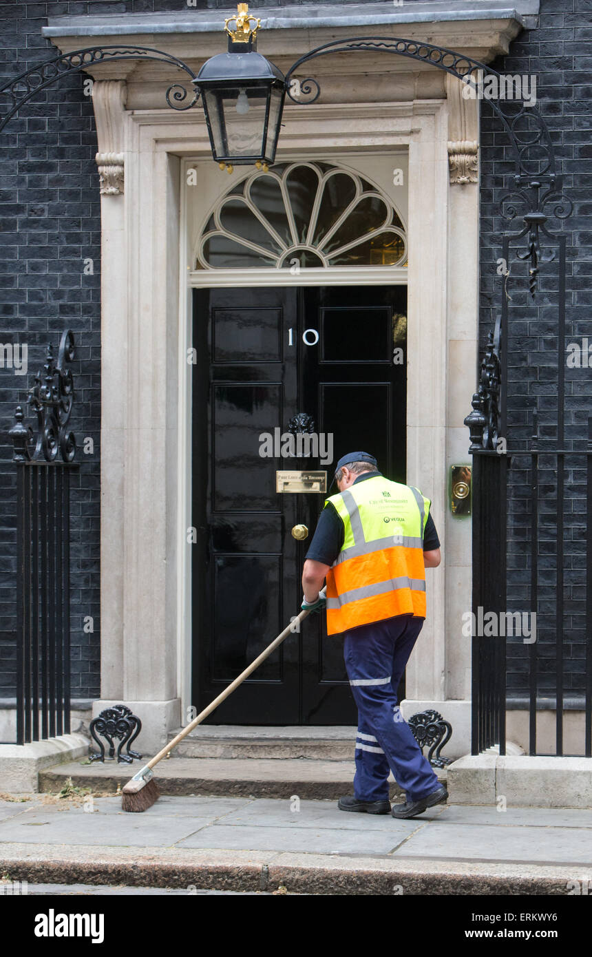 Roadsweeper spazzare la porta del numero 10 di Downing Street Foto Stock