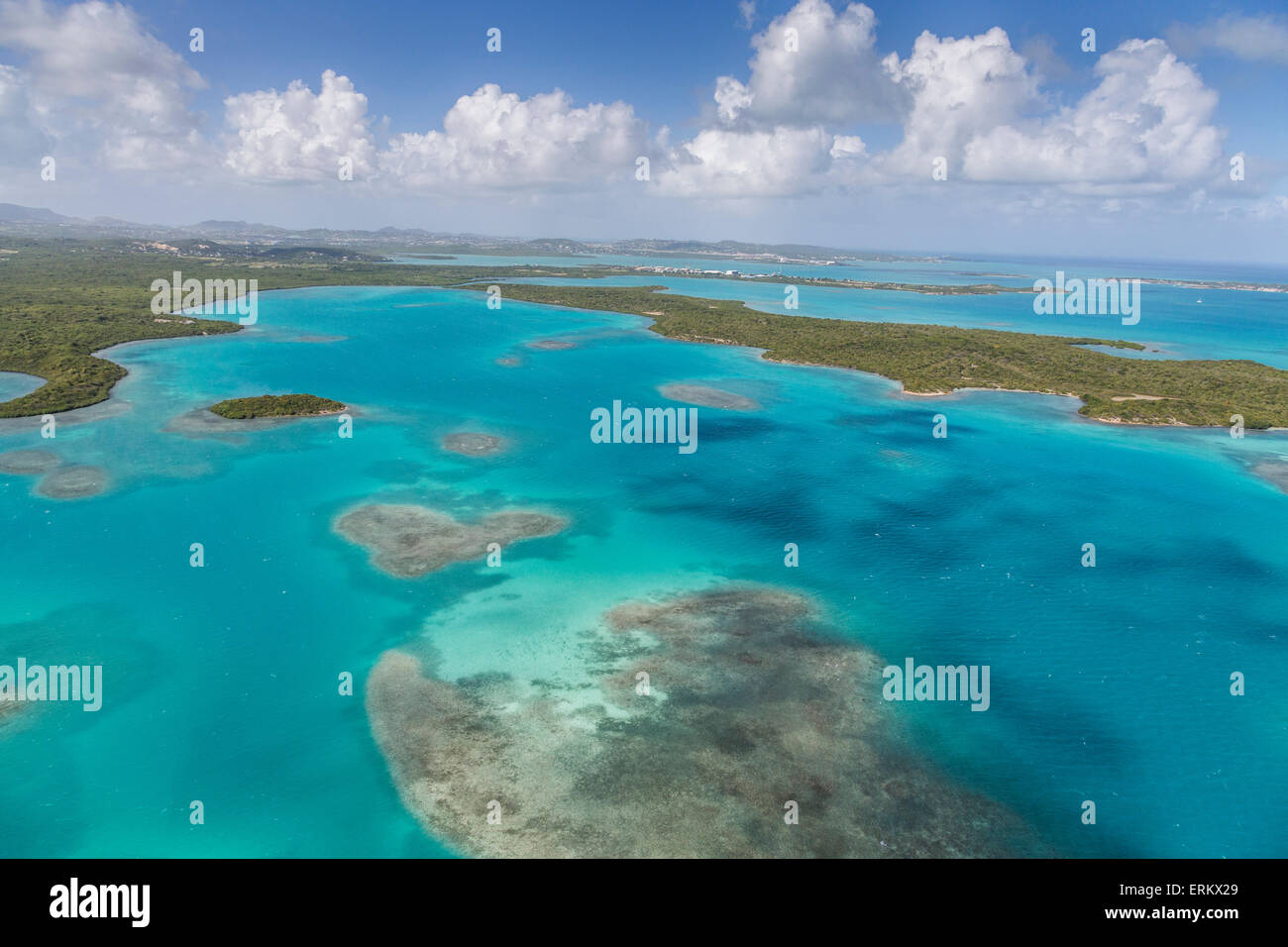 Vista aerea di sezioni di reef disseminati lungo la costa frastagliata e ricca di vegetazione tropicale di Antigua, Isole Sottovento Foto Stock