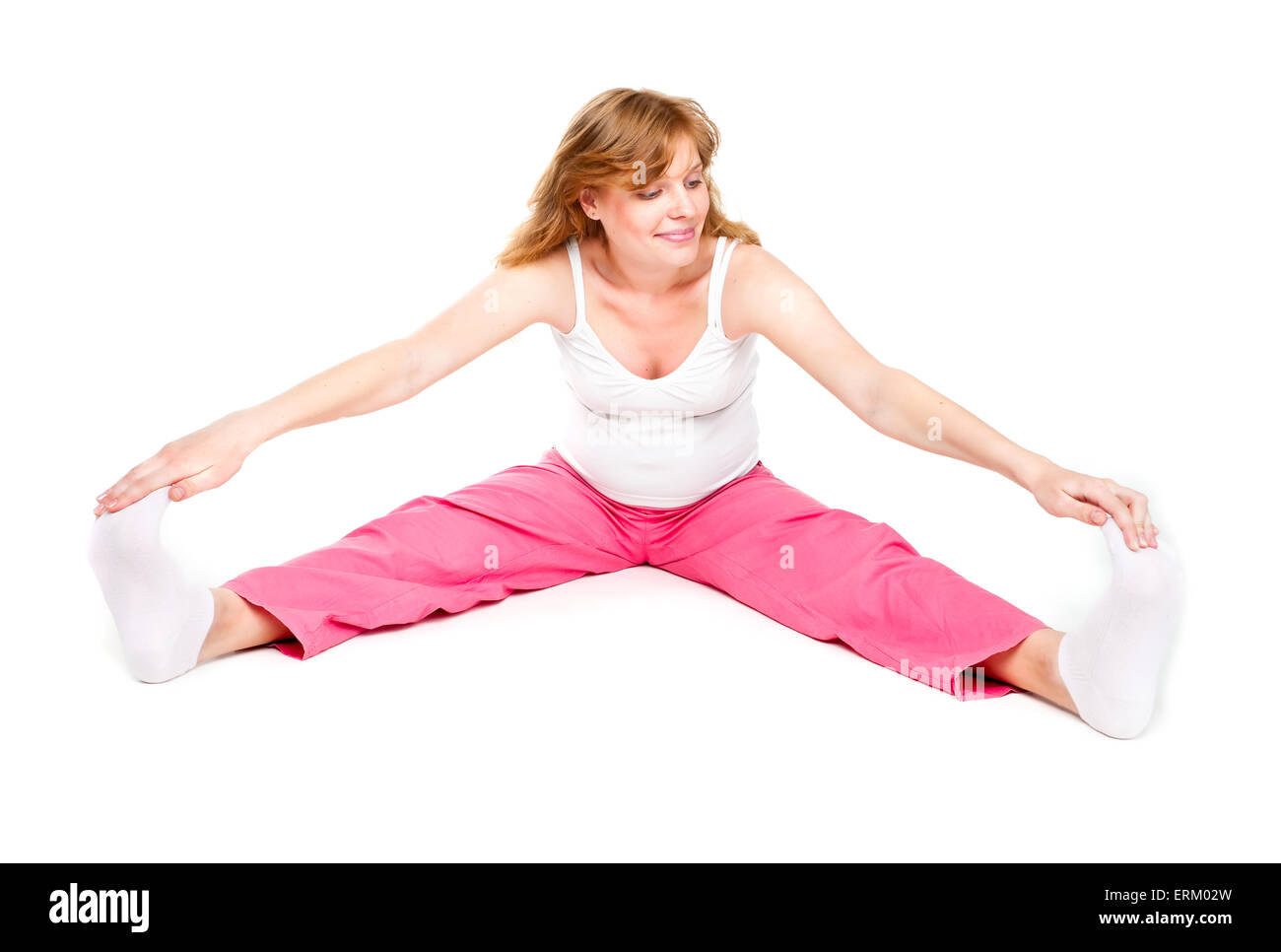 Giovane donna incinta facendo esercizi yoga - isolato su bianco. Foto Stock