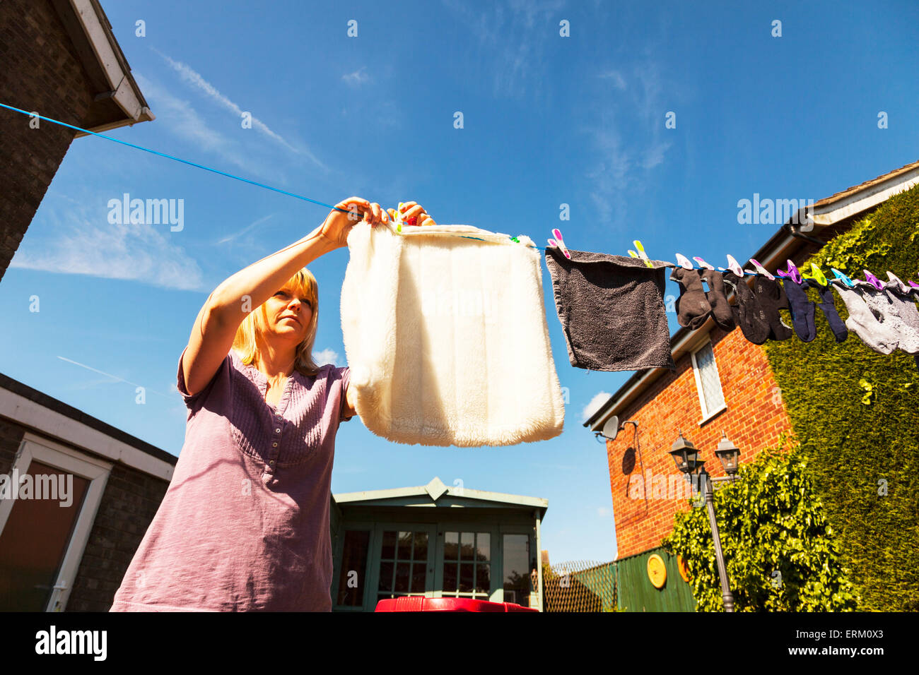 Appendere fuori il lavaggio a secco lady donna femmina calze laghetti linea pioli di ancoraggio servizio lavanderia chore womans lavorare mai fatto Foto Stock