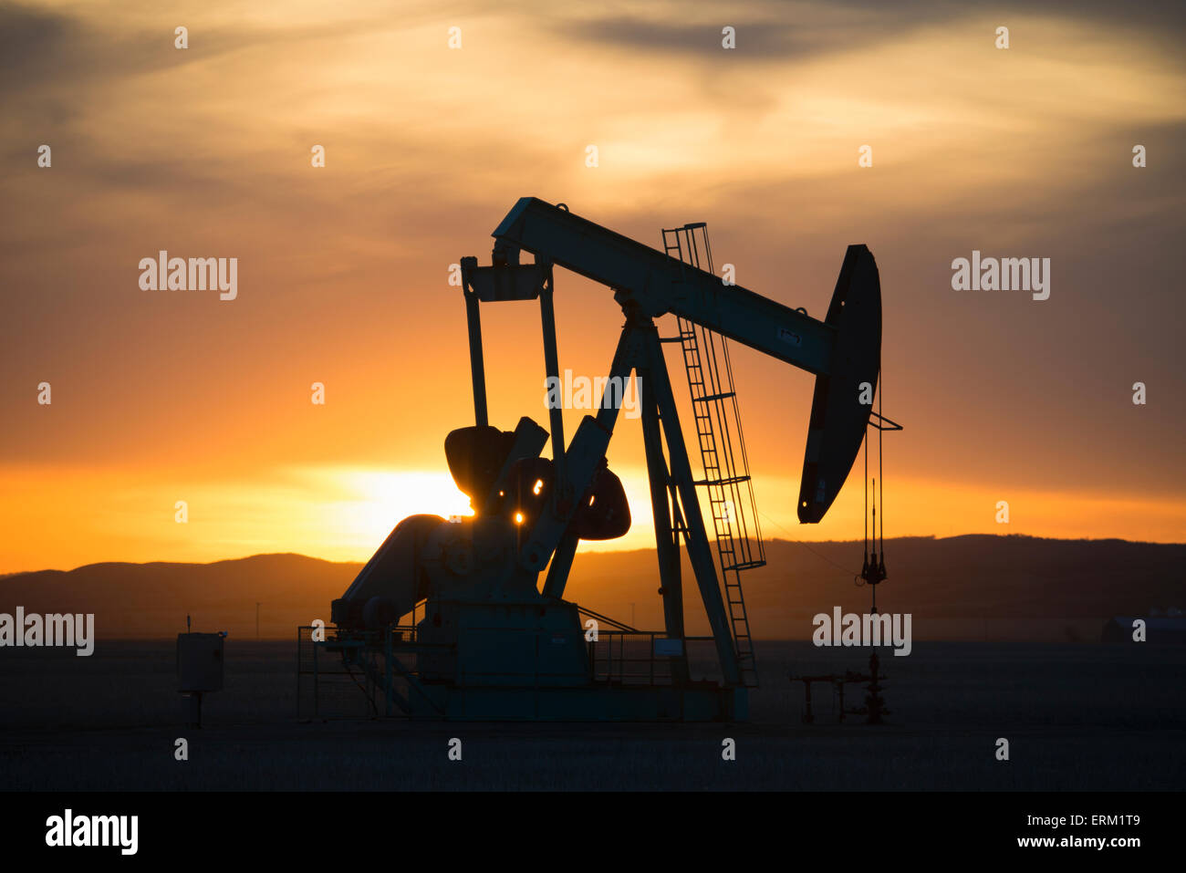 Un pumpjack a un olio sito di perforazione al tramonto. Foto Stock