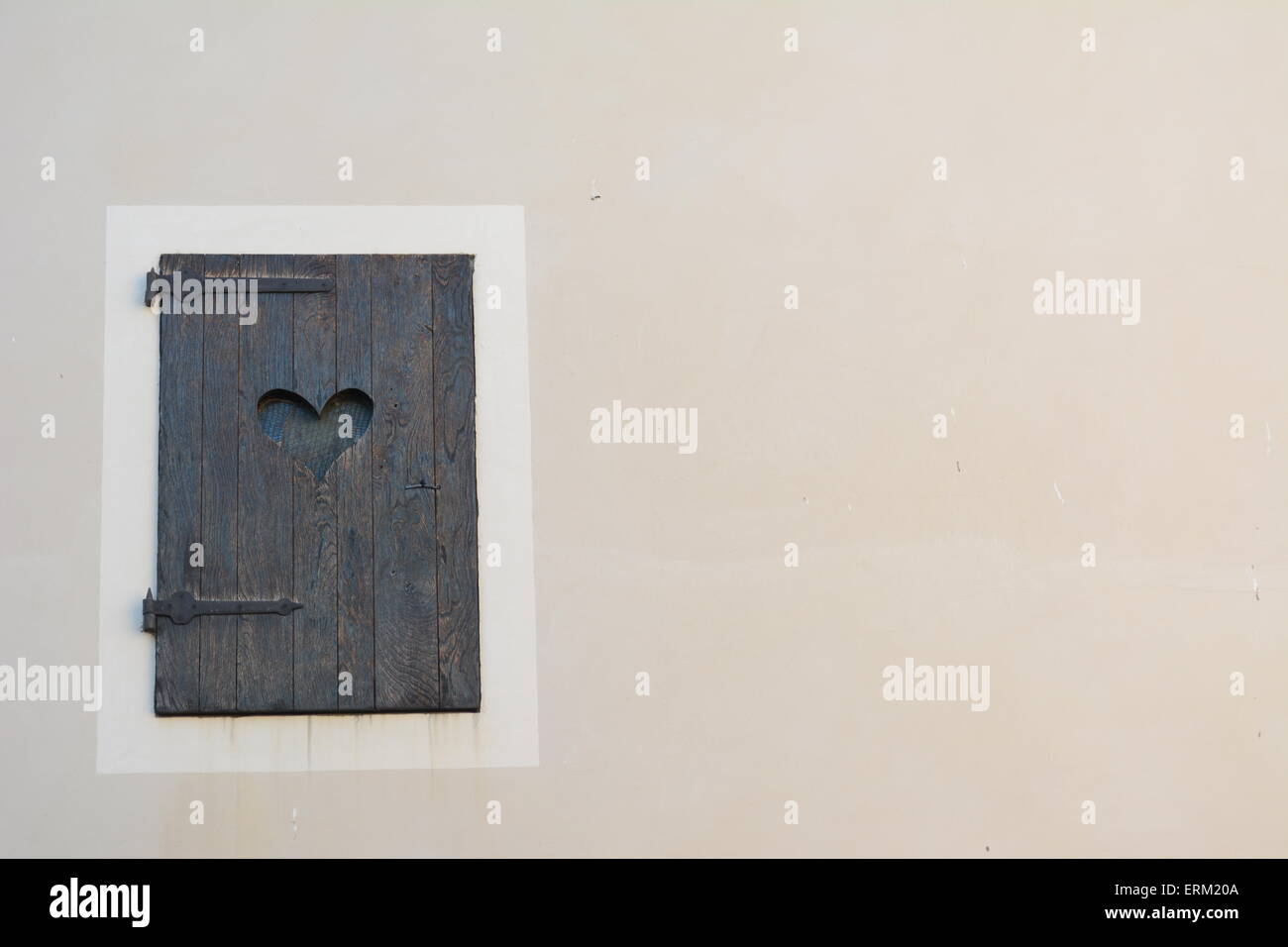 Il vecchio sportello di legno con taglio fuori amore cuore su uno sfondo luminoso Foto Stock