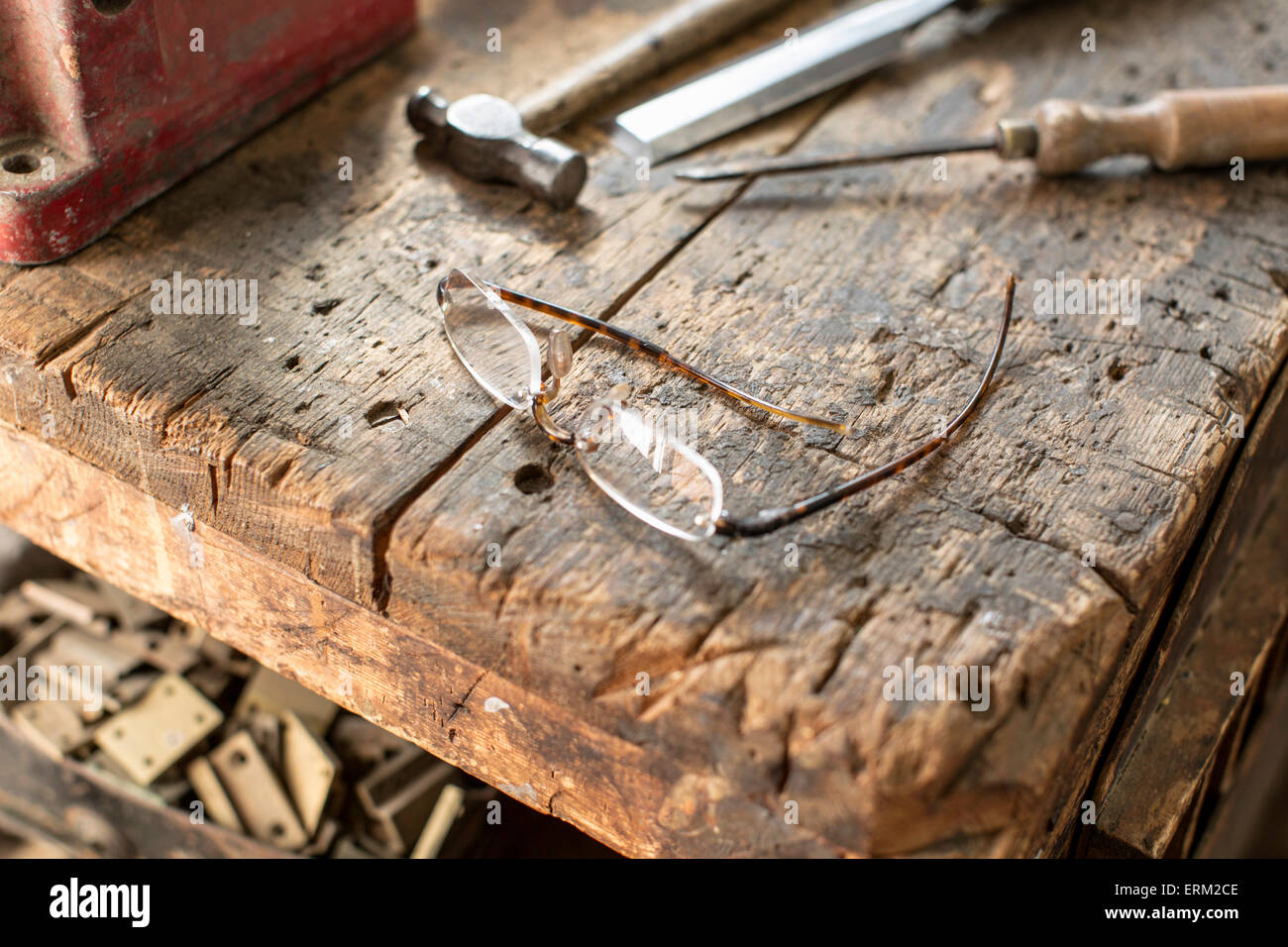 Mobili antichi restauratore's Workbench. Un usurato segnato il blocchetto di legno con bordi smussati, un martello e scalpello Foto Stock