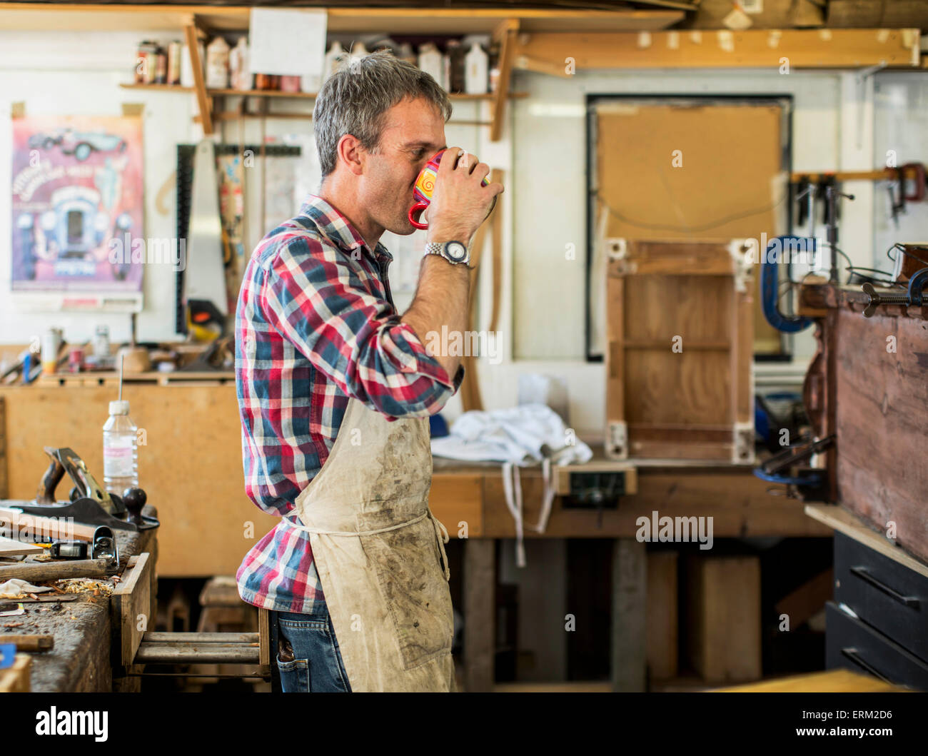 Un arredamento antico restauratore nella sua officina havng una pausa caffè. Foto Stock