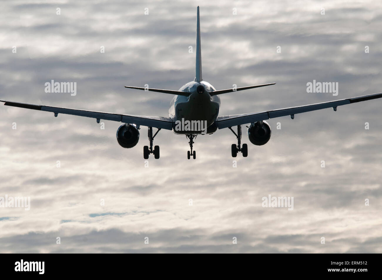 Aviogetti sull approccio finale, in parziale silhouette con sfondo di sparse in cloud Foto Stock