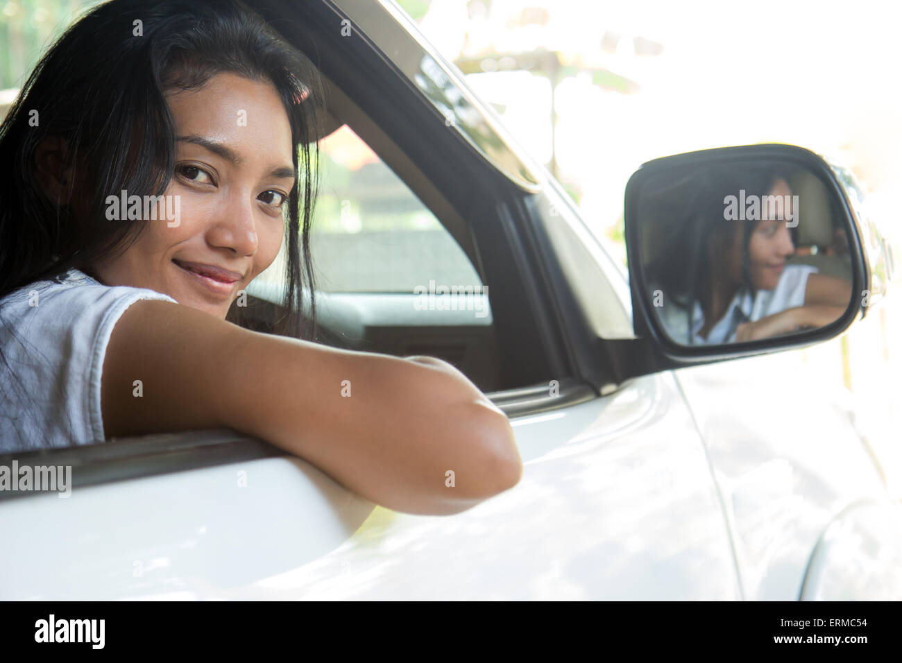 Giovane donna seduta in una macchina e guardando fuori dalla finestra Foto Stock