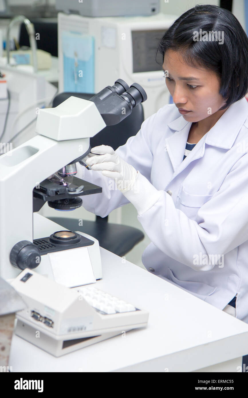 La donna lavora in un laboratorio con microscopio Foto Stock