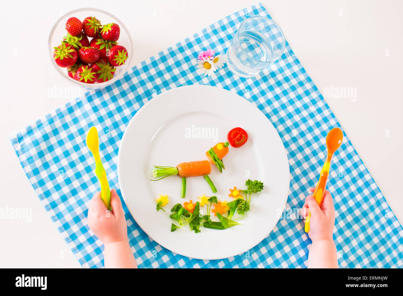 Un sano pranzo vegetariano per bimbi piccoli, ortaggi e frutta è servita come animali, bambino tenendo le mani a cucchiaio Foto Stock