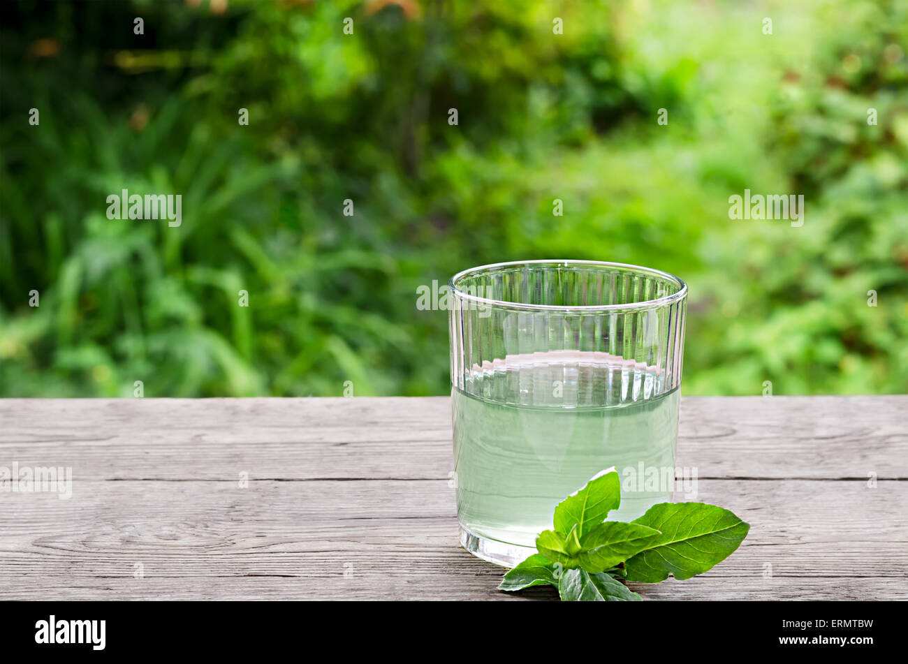 Acqua con menta su una tavola di legno Foto Stock
