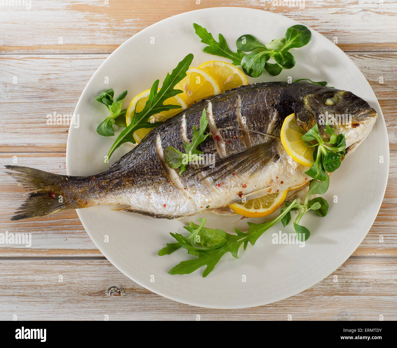 Fried Orate di mare sulla piastra con insalata fresca e limone. Cibo sano. Foto Stock