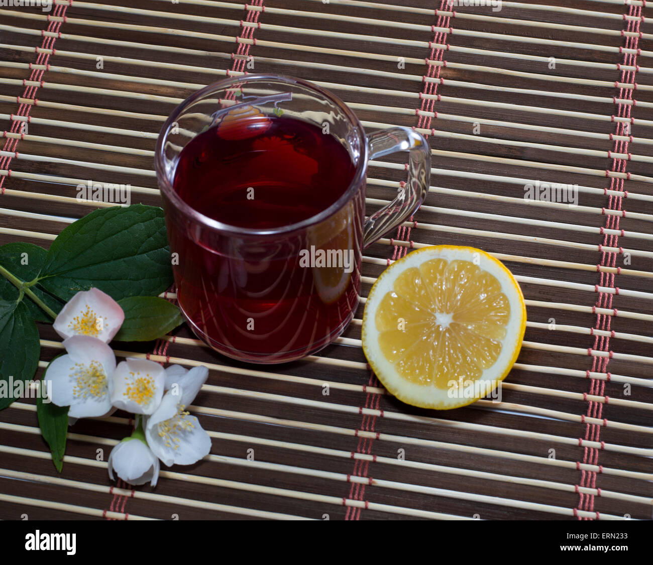 Bicchiere di tè rosso con un limone su un tappeto Foto Stock