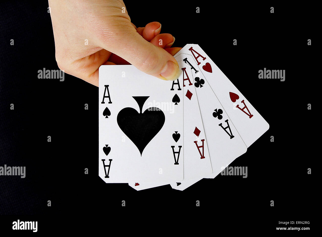 Croupier giocatore tenendo a portata di mano carta di credito asso di picche quattro di un tipo su sfondo nero Foto Stock