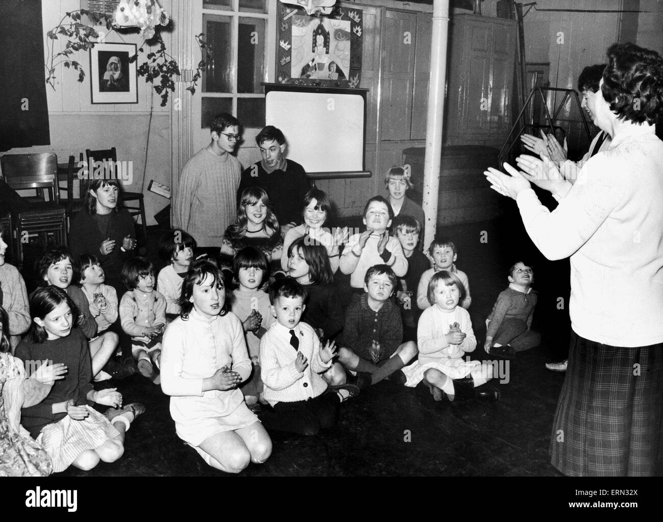 I bambini partecipano in un singalong condurre dalla onorevole Ann Walker e Miss Eileen Williams presso la vacanza centro giochi presso il Vescovo della Ryder Scuola, Gemma Street. Il 31 dicembre 1968. Foto Stock