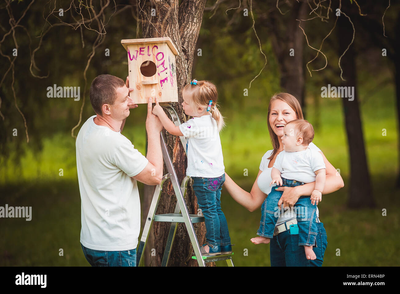La famiglia felice con legno birdhouse Foto Stock