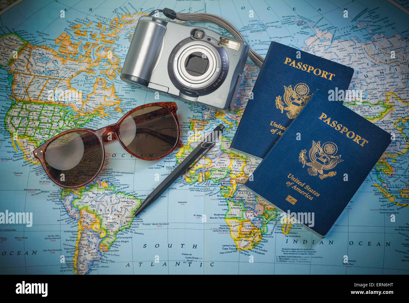 Il passaporto per viaggiare, telecamera e bicchieri su una mappa del mondo Foto Stock