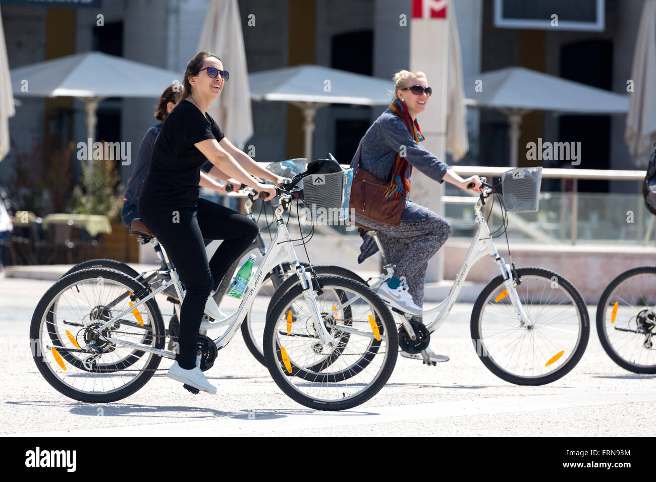 La donna in sella ad una bicicletta con amici cavallo nero square Lisbona Portogallo. Foto Stock