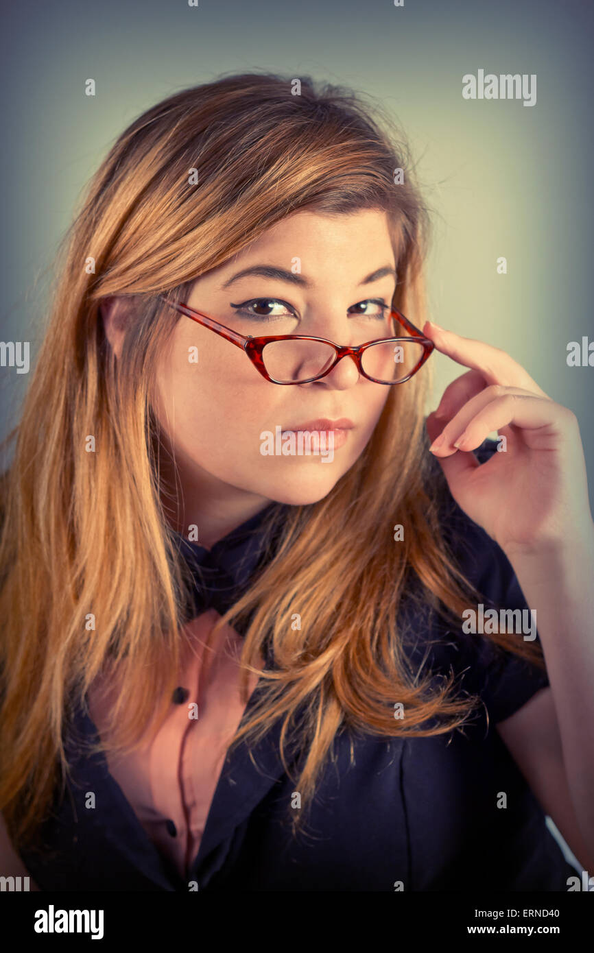 Carino da stupidi ragazza con gli occhiali da lettura in posa per un ritratto Foto Stock