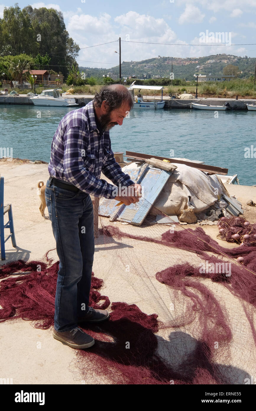 Pescatore cretese rammendo reti sulla banchina a Georgioupoli Creta Grecia Foto Stock