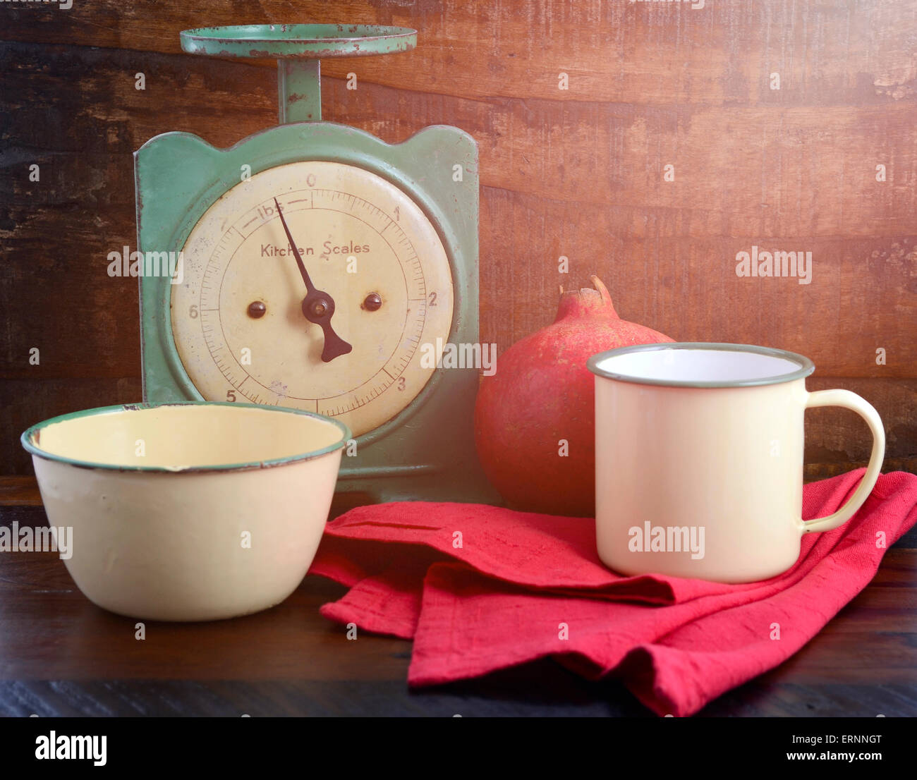 Vintage bilancia da cucina e tazze di stagno e padelle in scuro legno rigenerato sfondo, con applicata in stile vintage filtri e aggiunta di sun Foto Stock