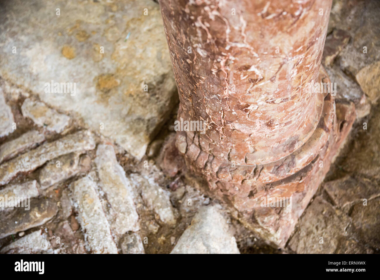 Antiche colonne di marmo rosso appoggiato sul pavimento di pietra Foto Stock