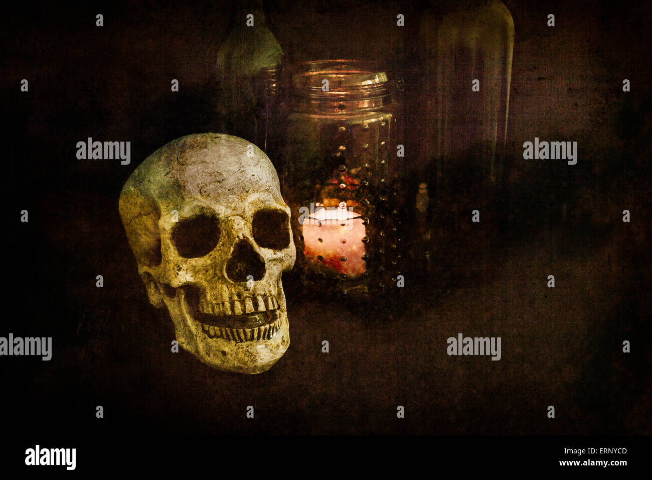 Un cranio si trova oltre una vecchia porta candele e bottiglie di vino; texture grunge look; immagine creata con una luce tecnica di pittura Foto Stock