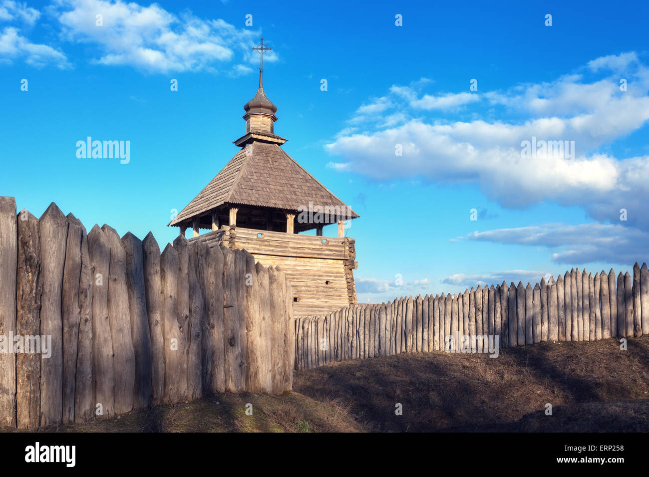 Il legno vecchio rustico edificio della chiesa e la recinzione di legno contro il cielo blu al tramonto Foto Stock
