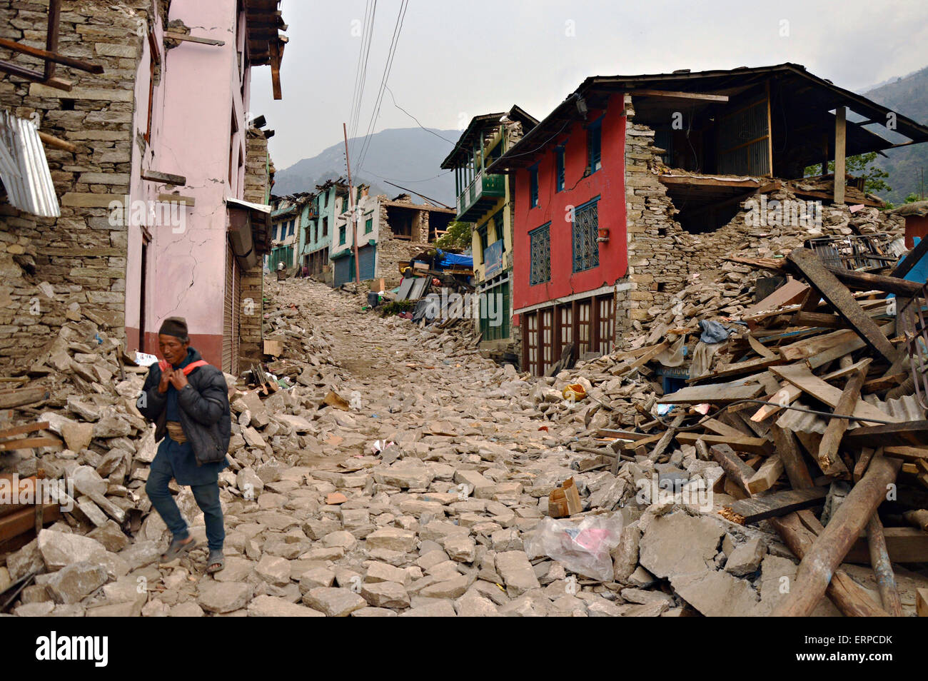 Un uomo nepalese passeggiate attraverso le rovine del suo villaggio Maggio 7, 2015 in Sindhupalchok, Nepal. Il devastante terremoto che ha colpito il piccolo regno del Nepal ha ucciso oltre 8 mila persone e distrutto gran parte del paese. Foto Stock