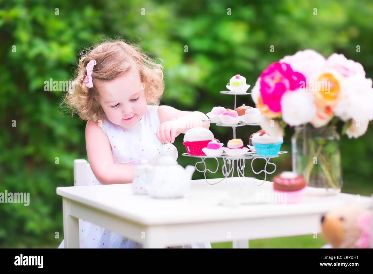 Adorabili Bimbi Divertenti Ragazza Con I Capelli Ricci Che Indossa Un Abito Colorato Per Il Suo Compleanno Giocando Tea Party Con Un Orsacchiotto Di Peluche Bambola Foto Stock Alamy