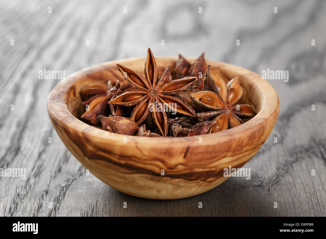 Anice stelle nella ciotola sul vecchio tavolo in legno di quercia close up foto Foto Stock