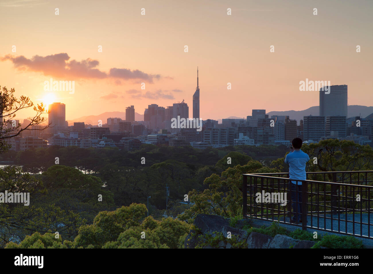 L'uomo prendendo foto della skyline della città da Fukuoka rovine del Castello al tramonto, Fukuoka Kyushu, Giappone Foto Stock