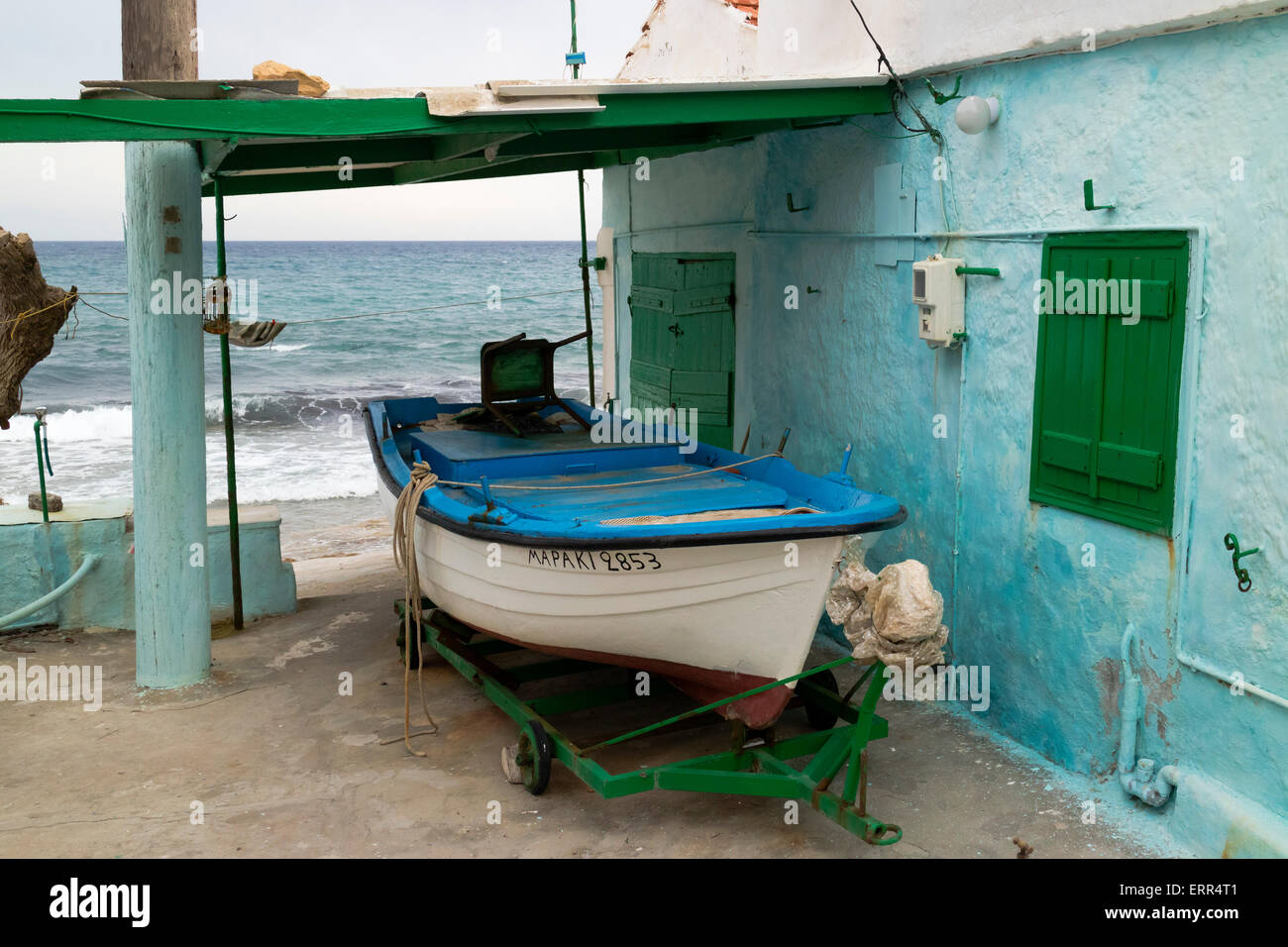 Piccola imbarcazione di pescatori di fronte a una casa in Mega Limnionas sull'isola di Chios, Grecia Foto Stock