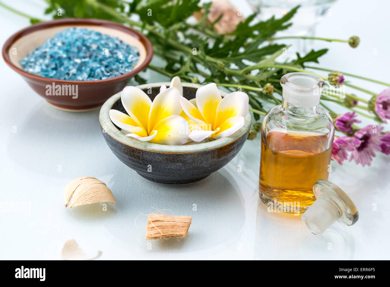 Concetto di Spa con fiori galleggianti, olio essenziale, il sale e il legno secco Foto Stock