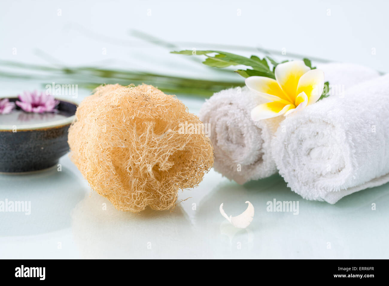 Concetto di Spa con fiori galleggianti, Loofah e fiore di asciugamani Foto Stock