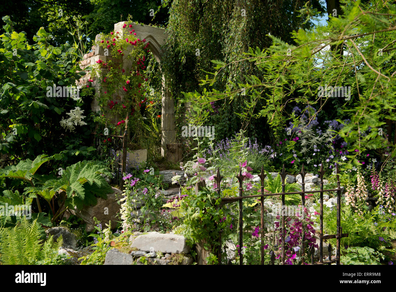 Un arco in pietra circondato da piantagione naturalistico nel dimenticata follia Giardino a Hampton Court Flower Show, 2014 Foto Stock