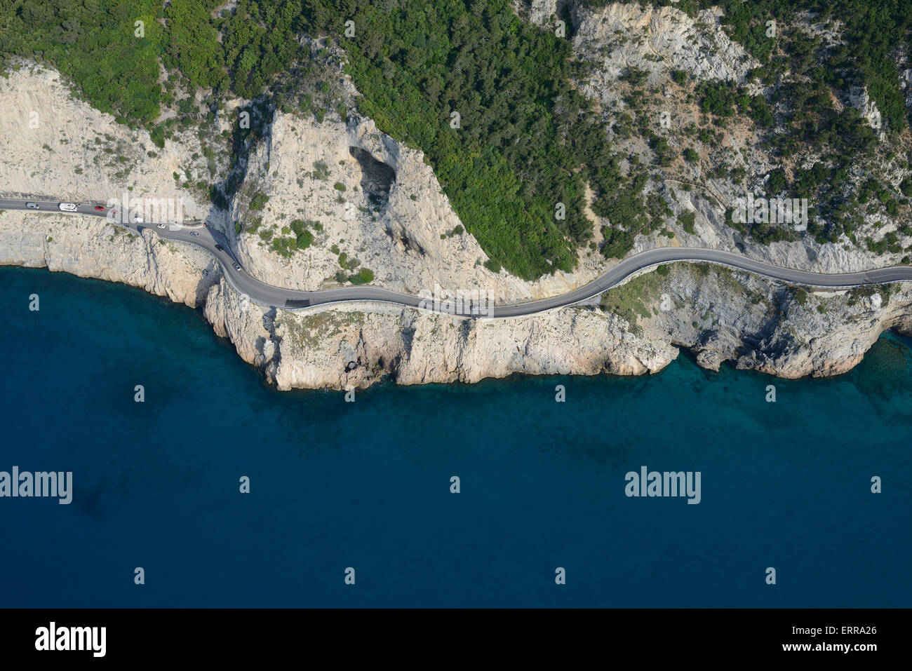 VISTA AEREA. Strada panoramica su una Corniche nelle scogliere precipitanti di Capo Noli. Noli, Provincia di Savone, Liguria, Italia. Foto Stock