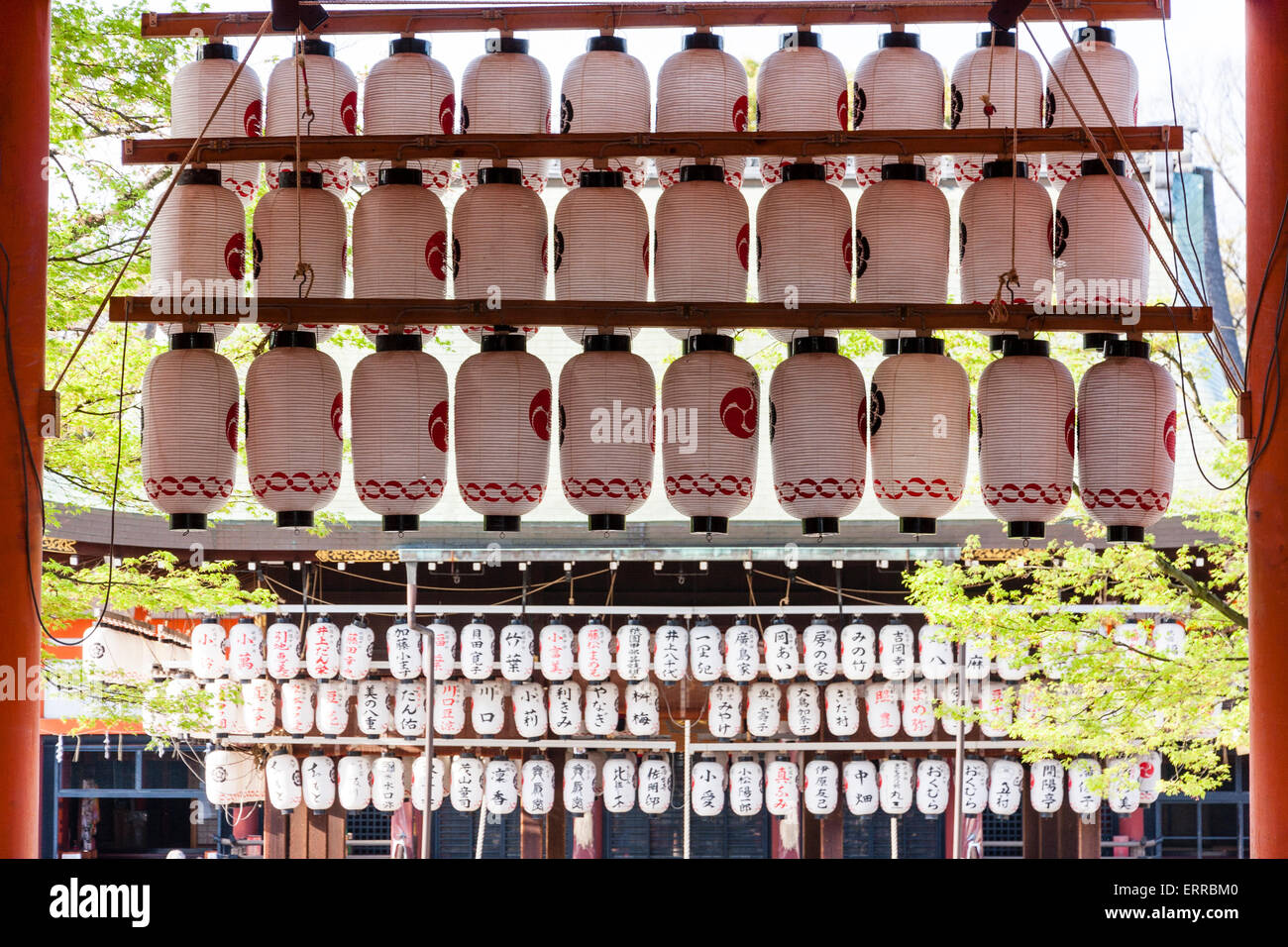 File di chochin, lanterne di carta, appese da una porta di vermiglio torii sull'ingresso si avvicina alla parte principale del santuario di Yasaka a Kyoto, Giappone. Foto Stock