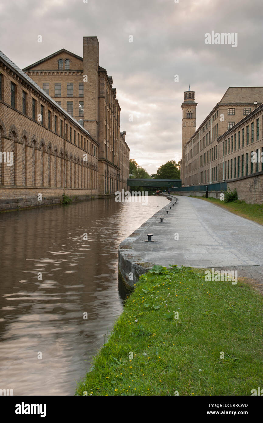 Storica e imponente, Salts Mill, un ex vittoriano mulino tessile, si distingue per l'alzaia - banche di Leeds Liverpool canal, Saltaire, Inghilterra, Regno Unito. Foto Stock