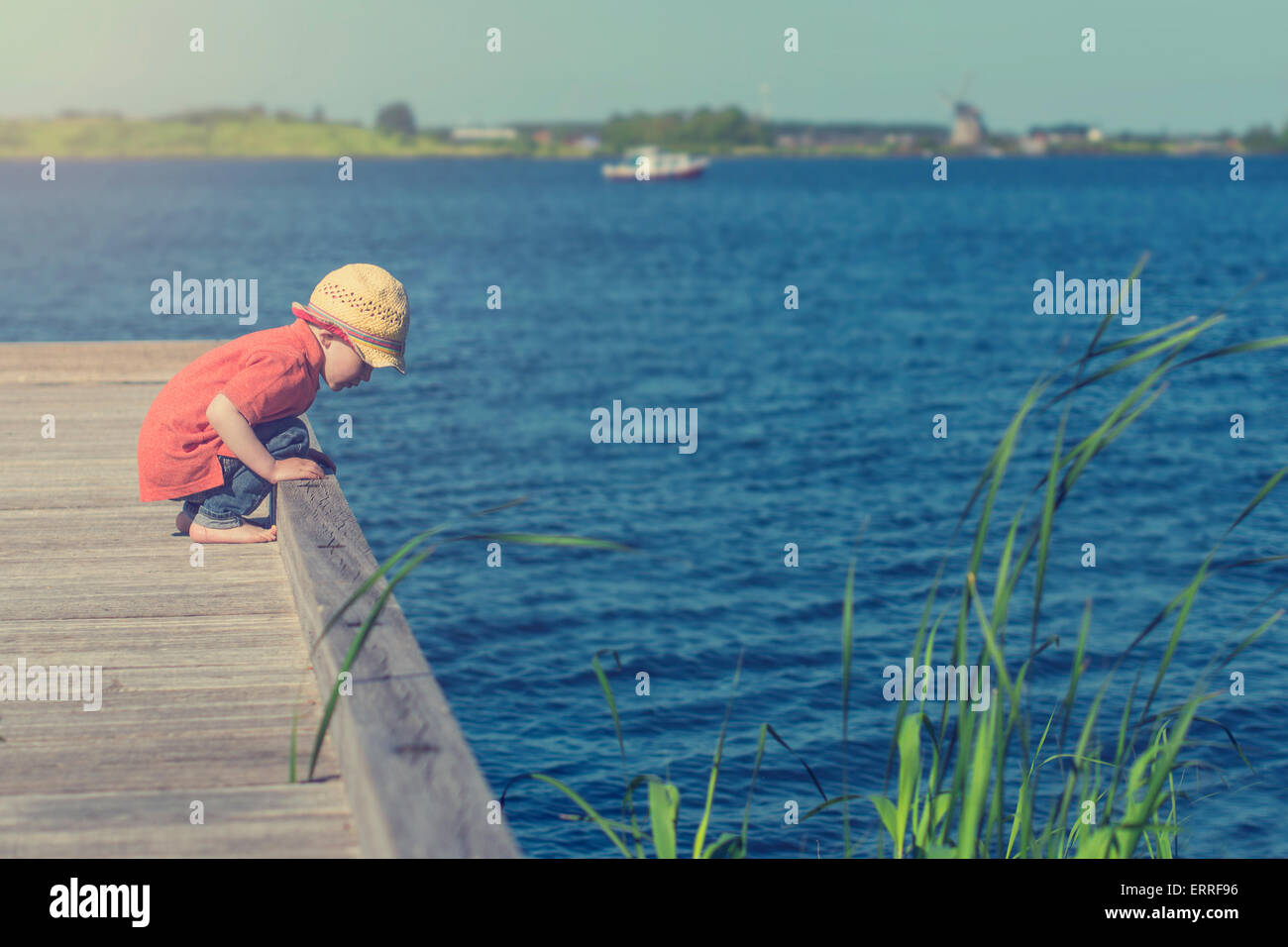 Carino il toddler giocando in riva al lago Foto Stock