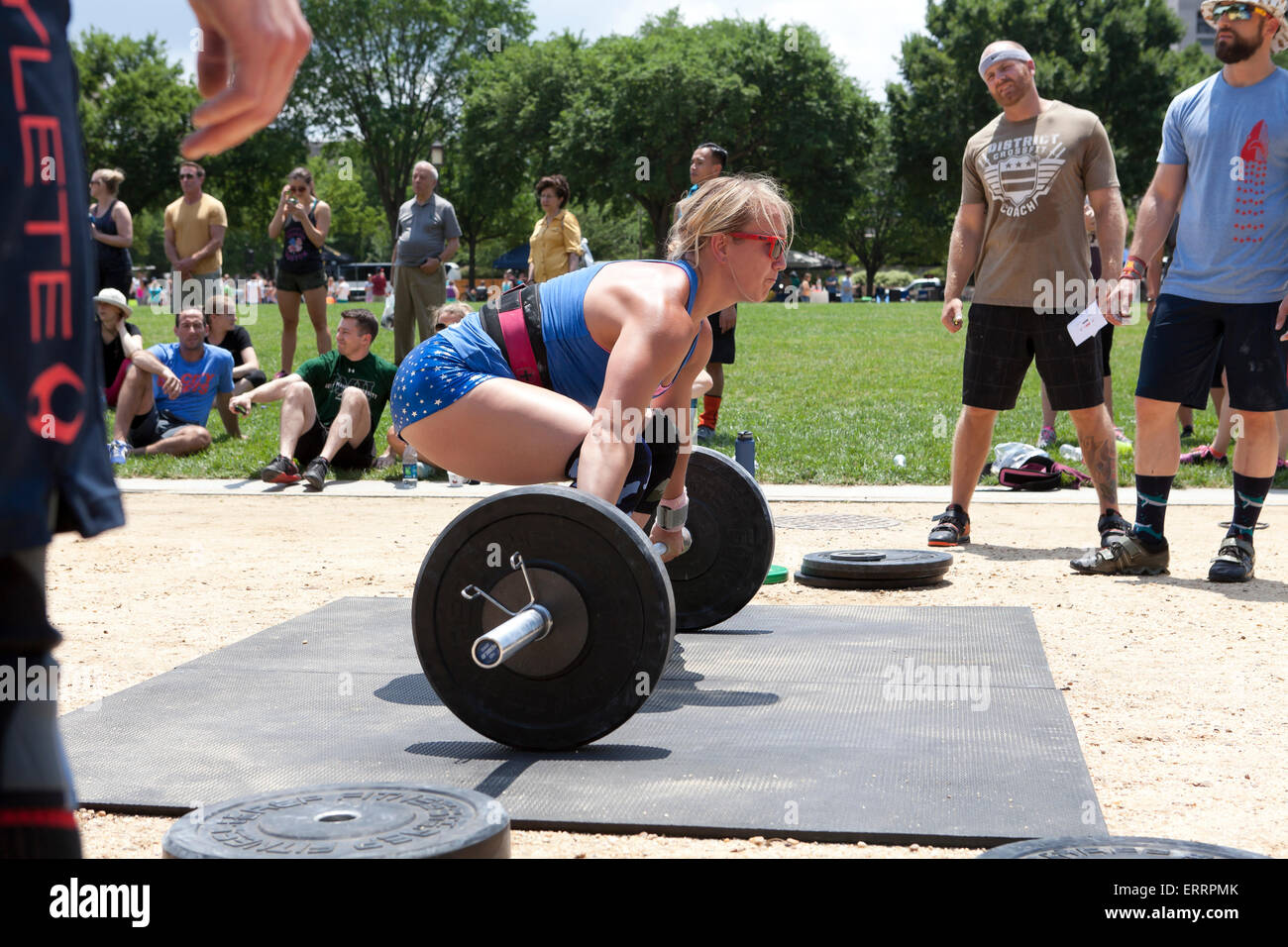 Donna di eseguire il sollevamento pesi ad un outdoor programma fitness - USA Foto Stock