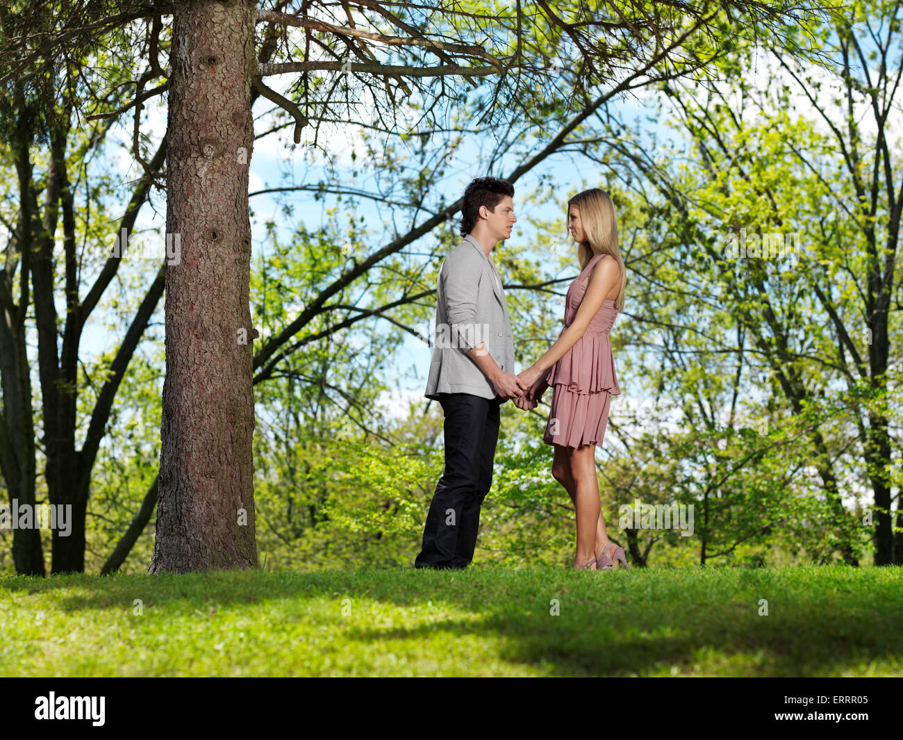 Licenza disponibile all'indirizzo MaximImages.com - coppia giovane e romantica che si tiene per mano in un parco Foto Stock