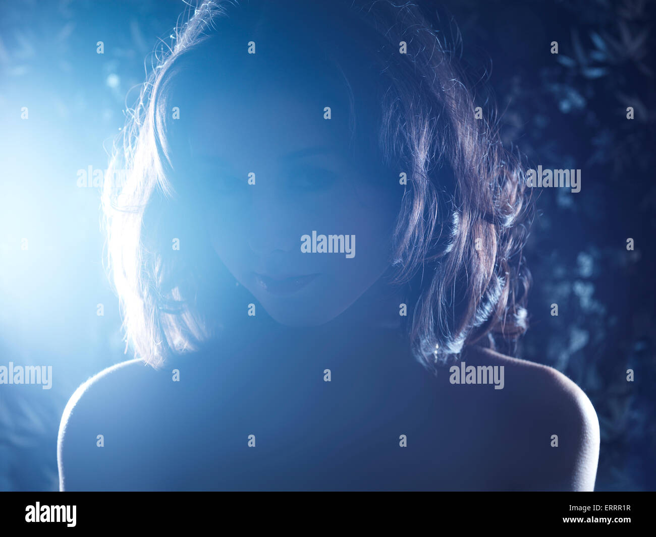 Dark drammatico ritratto di una giovane donna in condizioni di intensa luce posteriore Foto Stock