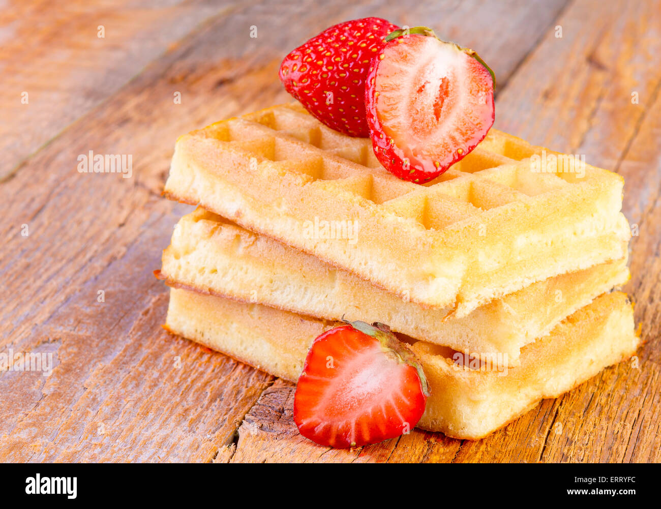 Waffles fatti in casa con fragole su sfondo di legno Foto Stock