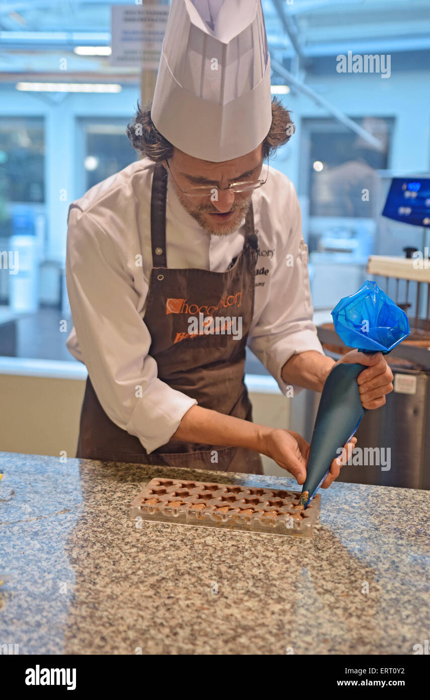 Un creatore di cioccolato ripieno a forma di stella cioccolatini in una dimostrazione presso il Museo del cioccolato di Brugge, in Belgio Foto Stock