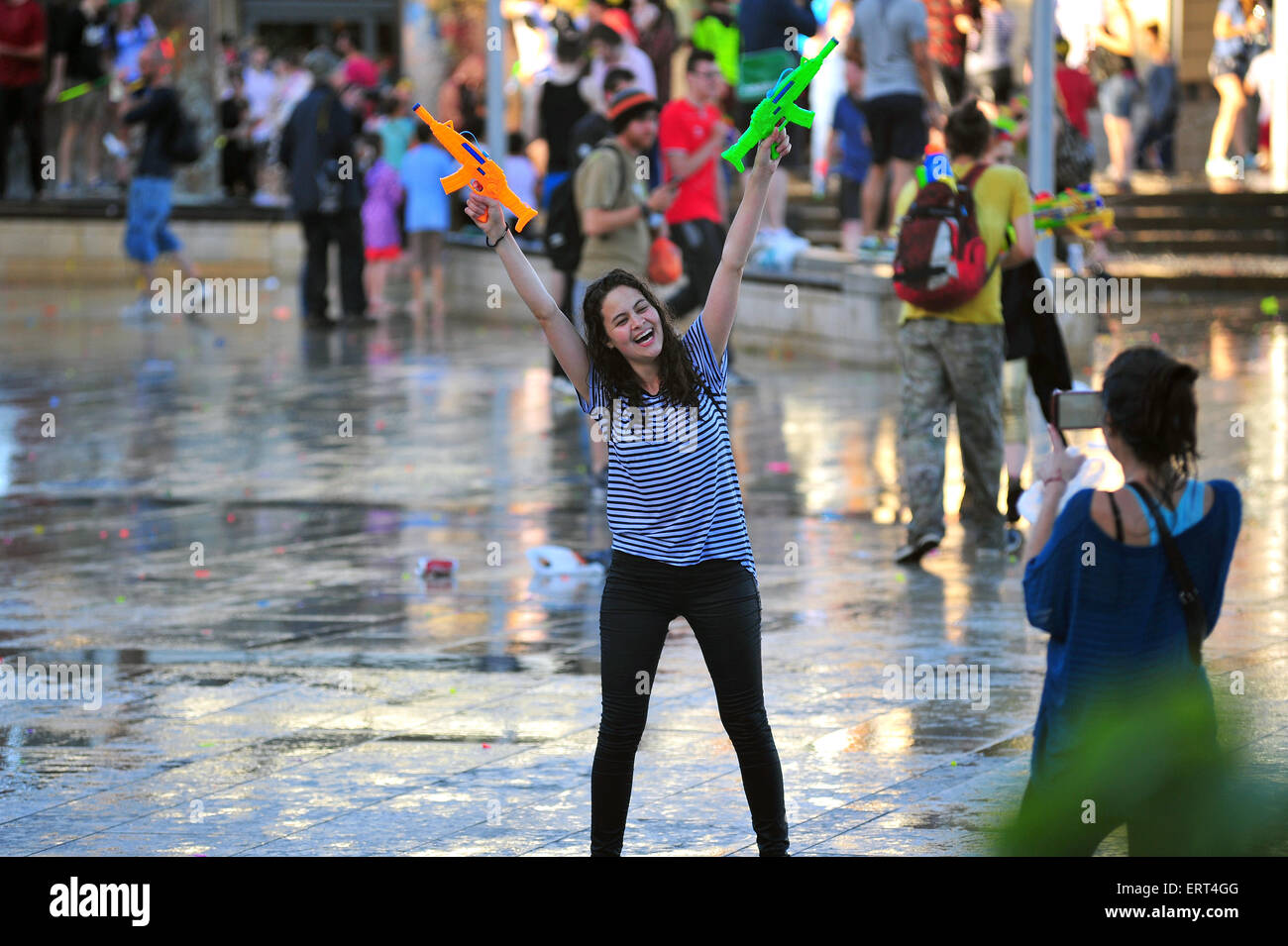 Una donna che mantiene le pistole ad acqua in posa per una fotografia durante un gigante di acqua lotta nel centro di Bristol. Foto Stock