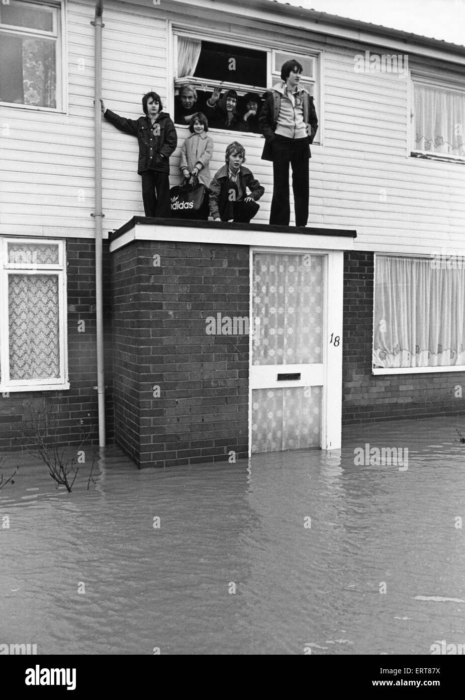 Rifugio per questa famiglia di Billingham è stato il tetto piatto di loro portico come la pioggia caduta nella notte ha causato il Billingham beck di scoppiare le sue rive. Il 29 marzo 1979 Foto Stock
