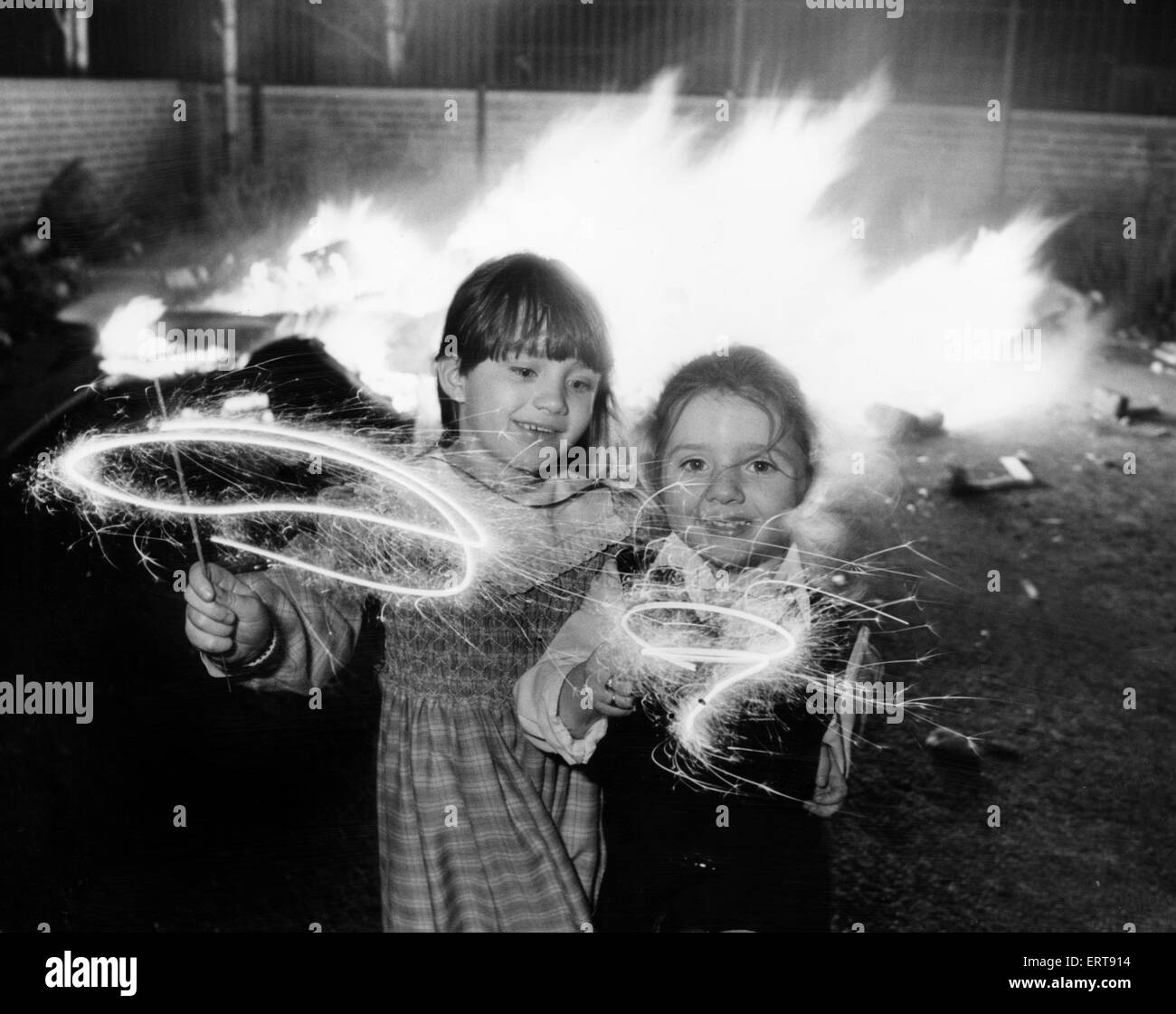 Chiara di età compresa tra i 6 e Lindsay Gerard invecchiato quattro (a destra) godendo le loro botti a un falò improvvisato party in Kensington, Liverpool. 5 Novembre 1986 Foto Stock