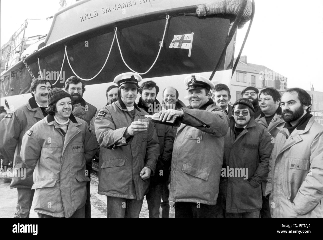 Scialuppa di salvataggio equipaggio a Redcar condividendo un drink con il sir James Knott Oakley 37 ft scialuppa di salvataggio in background. 12 Dicembre 1982 Foto Stock