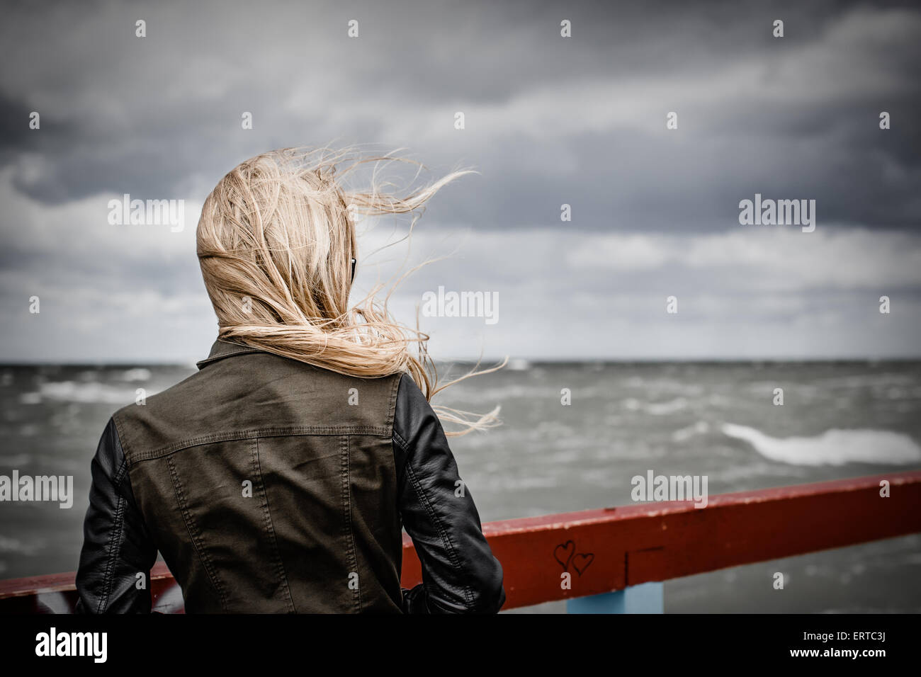 Ragazza bionda guardando il mare Foto Stock