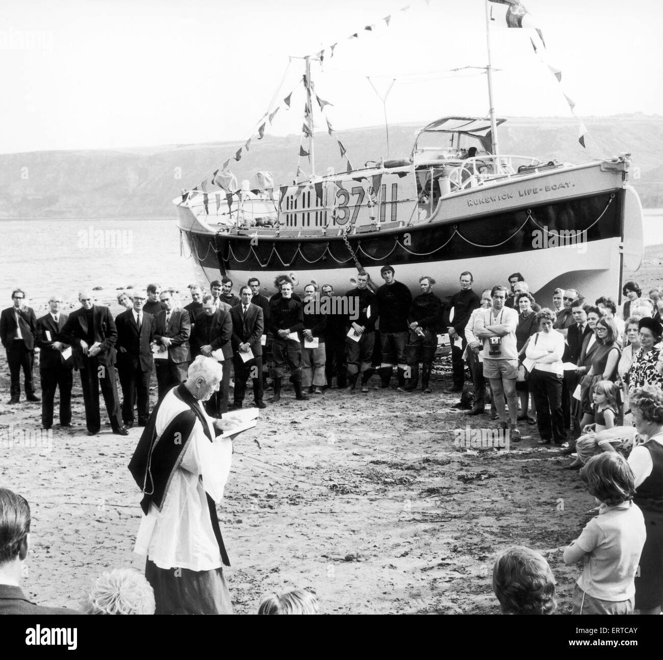 Per i turisti e residenti locali entra a far parte di un servizio in mare di ridedicarci Runswick Bay's 37ft scialuppa di salvataggio, il Royal Thames. Condotto dal Venerabile Stanley Linsley, Arcidiacono di Cleveland e cappellano della regina. Il Royal Thames sostituito il Elliott gi Foto Stock